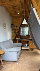 a living room with a couch and a swing at Glamping MORET Tiny House M1 in Los Lirios