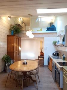 a kitchen with a wooden table in a kitchen at Le Chablis étoilé in Champagnole