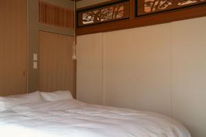 a bedroom with a white bed and two windows at 宿屋 余白丨yadoya yohaku in Wakayama