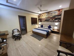 a hotel room with a bed and a chair at The Mansion Courtyard in Mathura