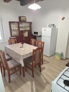 a kitchen with a table and chairs and a refrigerator at Aranymoha Vendégház in Szőce