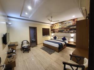 a hotel room with a bed and a television at The Mansion Courtyard in Mathura