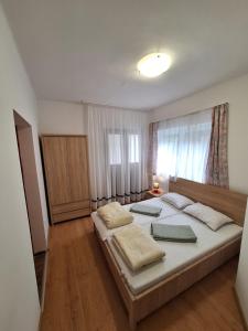 a bedroom with a large bed with two pillows on it at Aranymoha Vendégház in Szőce