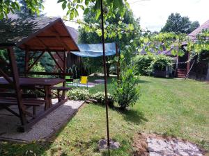 a garden with a picnic table and a pole in the grass at Aranymoha Vendégház in Szőce