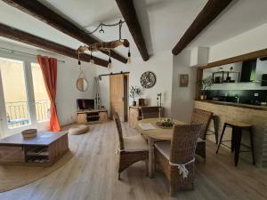a living room with a wooden table and chairs at La Maison Delle Spellé - Meublé de Tourisme 4 étoiles in Piolenc