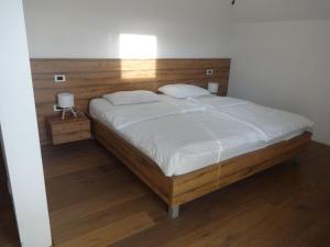 a bedroom with a large bed with a wooden headboard at Hiša Kovač in Velesovo +107 photos