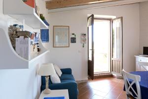 a living room with a blue couch and a window at Salina Holiday Home in Calasetta