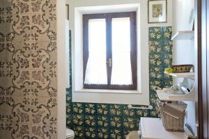 a bathroom with a toilet and a window at Salina Holiday Home in Calasetta +32 photos