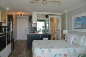 a bedroom with a bed and a kitchen in it at Beachfront 8th floor Studio - Stunning View in Galveston +23 photos