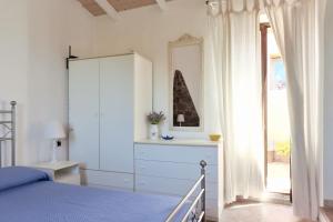 a bedroom with a bed and a dresser and a window at Salina Holiday Home in Calasetta