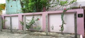 a pink fence with plants growing on it at Aiswarya illam in Chidambaram