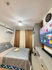 a bedroom with a bed and a flat screen tv at Pinili Homestay in Suba
