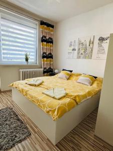 a bedroom with a large bed with a yellow blanket at Apartment city centrum in Nitra