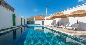 a swimming pool with chairs and umbrellas on a house at Villa UpTown in Mostar +87 photos