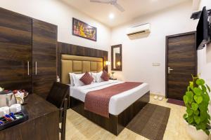 a hotel room with a bed and a desk at Hotel Kiara - Near Delhi Airport in New Delhi