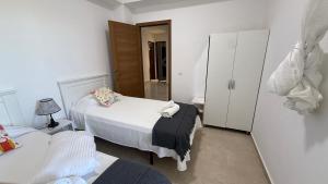 a small bedroom with two beds and a closet at Ventana al mar in Tangier