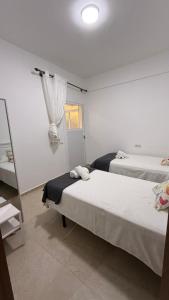 a bedroom with two beds and a window at Ventana al mar in Tangier