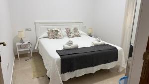 a bedroom with a white bed with two stuffed animals on it at Ventana al mar in Tangier +14 photos