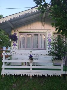 a small house with a bench in front of it at Căsuța Veselă in Tătuleşti