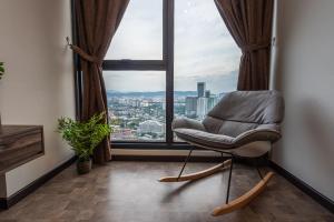a chair in a room with a large window at KLCC Expressionz by WGS, 300Mbps WiFi in Kuala Lumpur