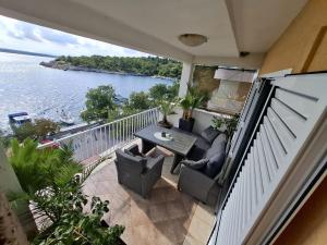 a balcony with a table and chairs and a view of the water at Apartments and Rooms Lucia&Veronica in Dramalj