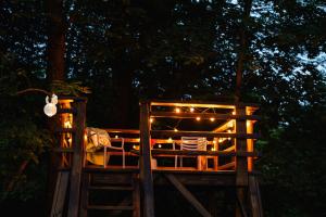 a tree house with lights on it at night at Agroturystyka Akacjowe Zacisze- pokoje ze śniadaniami, sauna, balia, tarasy wśród drzew, slow life in Stańkowa