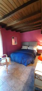 a bedroom with a blue bed in a red wall at La Dueña I in Miranda del Castañar