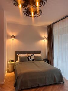 a bedroom with a large bed with two lights at Opal Villa in Băile Tuşnad +14 photos