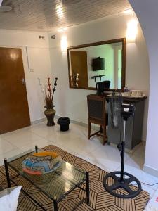 a living room with a glass table and a mirror at Green Whisper BnB in Umtali +11 photos