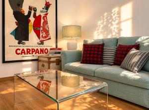 a living room with a blue couch and a glass table at ComeCasa Langhe Garden House-Pace e Panorama a Benevello in Benevello