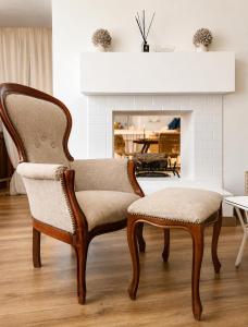 a pair of chairs in a living room with a fireplace at ComeCasa Langhe Garden House-Pace e Panorama a Benevello in Benevello +15 photos