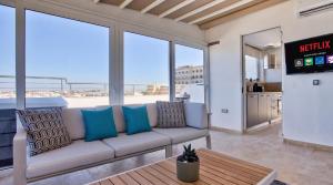 a living room with a couch and a table at Valletta Luxury 4-Bedroom Duplex with Stunning Sea Views Private Terrace and Jacuzzi in Valletta