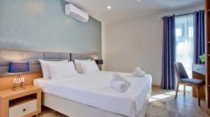 a bedroom with a white bed and a desk and a chair at Valletta Luxury 4-Bedroom Duplex with Stunning Sea Views Private Terrace and Jacuzzi in Valletta
