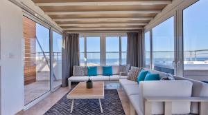 a living room with a couch and a table at Valletta Luxury 4-Bedroom Duplex with Stunning Sea Views Private Terrace and Jacuzzi in Valletta +40 photos