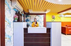 a woman at the counter of a dental office at Hotel Vibe Blue Sec 70, Near Kailash Hospital & Sec 61 -52 Metro in Noida