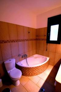 a bathroom with a bath tub and a toilet at Villa Rodia in Potos +38 photos