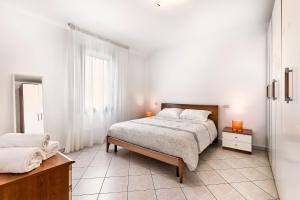 a white bedroom with a bed and a window at Eden Beach House - Host Solution in Cavallino-Treporti