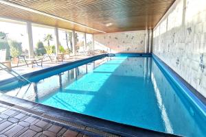 a swimming pool with blue water in a building at Panorama Maggiore Apartment with Pool in Locarno - Happy Rentals in Locarno