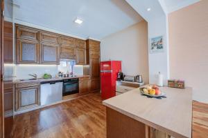 a kitchen with a red refrigerator and a bowl of fruit on a counter at Panorama Maggiore Apartment with Pool in Locarno - Happy Rentals in Locarno