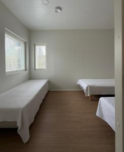 a room with two beds and two windows at Villa Valkeinen in Yli-Lesti