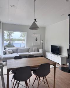 a living room with a table and chairs and a couch at Villa Valkeinen in Yli-Lesti