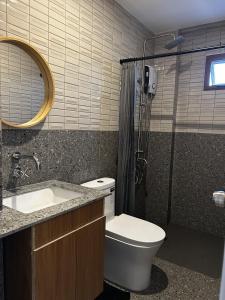 a bathroom with a shower and a toilet and a sink at Ikigai Narvacan Hometel in Narvacan