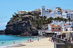a group of people on a beach near the ocean at Jandia Arena Habitación con baño - aire acondicionado in Morro del Jable