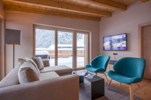 a living room with a couch and two chairs at Postresidenz in Mayrhofen