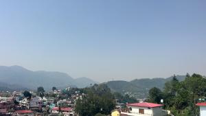 a view of a city with mountains in the background at Soar Serenity Homes in Pithorāgarh