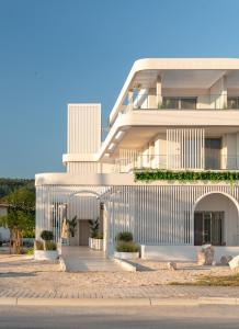 a large white building with a building at FOS Luxury Suites in Nikiti
