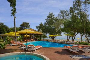 a pool at a resort with chairs and umbrellas at Tube Resort by EHM in Koh Rong Sanloem