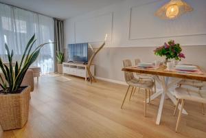 a living room with a dining table and a television at HelApart - Rodzinny in Hel