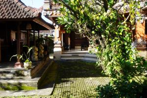 a courtyard of a house with a tree at Tegeg's Homestay in Keramas