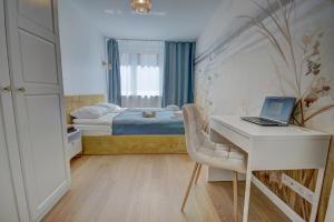 a bedroom with a desk and a bed with a laptop at HelApart - Rodzinny in Hel